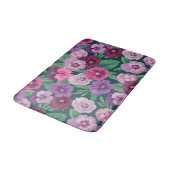 Farbenfrohe Stiefmütterchen auf dunkelgrünblau Badematte (Schrägansicht)