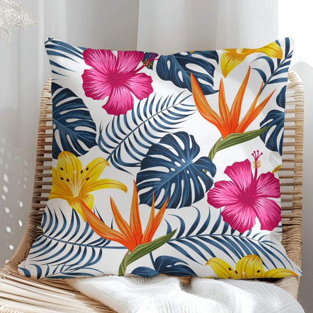 Farbenfrohe tropische Gestaltung auf einem weißen  Kissen (Colorful tropical design on a white pillow in a sunny rattan armchair.)