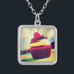 Farbenfroher Cupcake mit Cherry oben Versilberte Kette<br><div class="desc">Ein helles sommerliches Foto eines köstlichen Kuchens. Dieses Bild hat weiße flauschige Wolken und Berge im Hintergrund. Der leckere Kuchen ist in einem hellrosa und lila roten Wrapper enthalten. Der Cupcake selbst ist eine Kombination aus Vanillekuchen und Schokoladeneis mit einer saftigen Kirsche oben mit einem langen roten Stamm. Der Cupacake...</div>