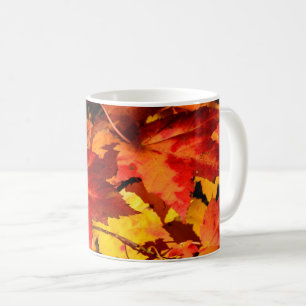 Farbige Blätter im Herbst, goldfarbenes orangefarb Kaffeetasse