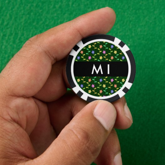Farbige Blume, grüner Hintergrund, schwarz Pokerchips (Hand)
