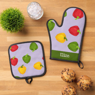 Farbige Glockenbläser-Paprikaschoten auf lila Ofenhandschuh & Topflappen-Set