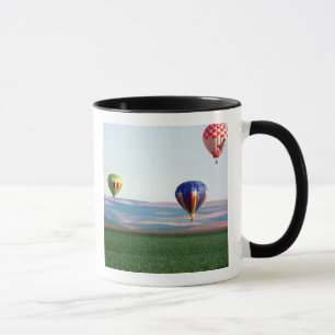 Farbige Heißluftballons schweben über Weizen Tasse