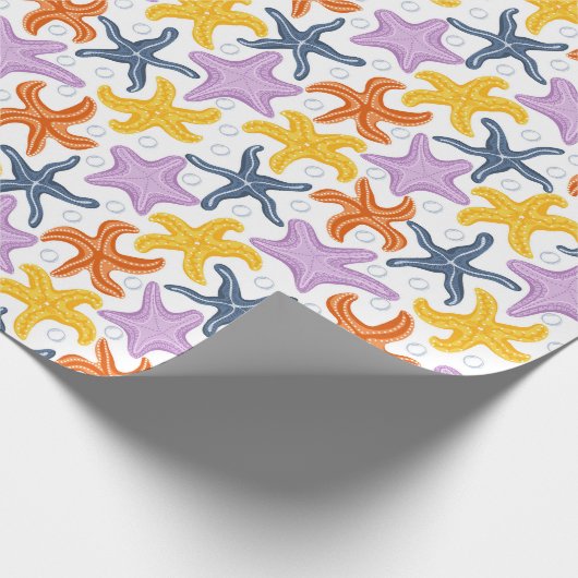 Farbige Seesterne auf Weiß Geschenkpapier (Ecke)