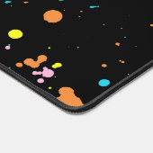 Farbige Spritzer auf schwarz Schreibtischunterlage (Ecke)