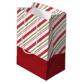 Feierlicher Mops in Roter Weihnachtsmannmütze mit  Mittlere Geschenktüte (Rückseite Schrägansicht)