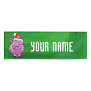 Feierliches Schwein in Weihnachtsmannmütze auf Grü Namenschild