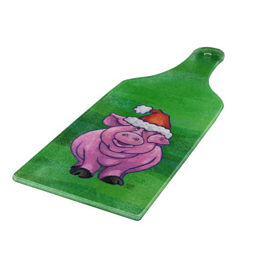 Feierliches Schwein in Weihnachtsmannmütze auf Grü Schneidebrett (Ecke)