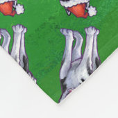 Feiernder Husky in Weihnachtsmannmütze auf Green Fleecedecke (Ecke)
