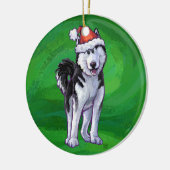 Feiernder Husky in Weihnachtsmannmütze auf Green Keramikornament (Links)