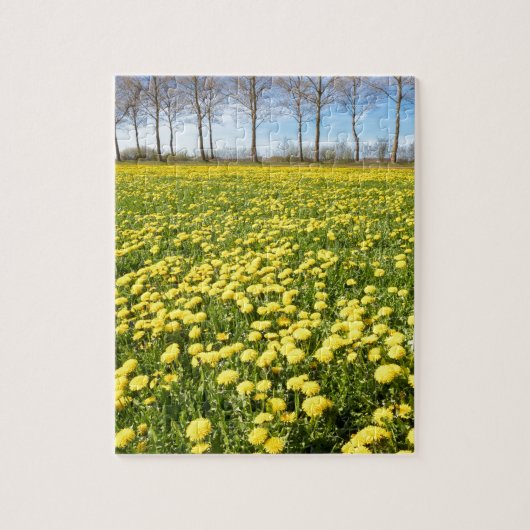 Feld des gelben Löwenzahns im Gras mit Baumlinie Puzzle (Vertikal)