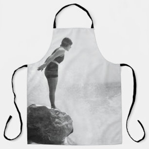Female swimmer on rock above crashing surfvintage, schürze