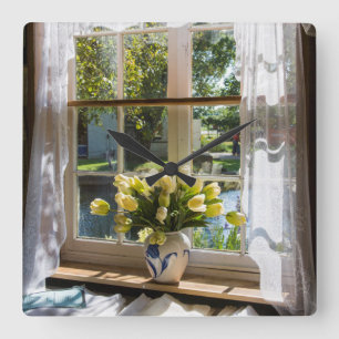 Fenster mit Spitzenvorhang und Tulpen Quadratische Wanduhr