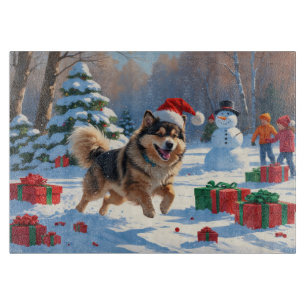 Finnischer Lapphund läuft durch Schnee mit Weihnac Schneidebrett