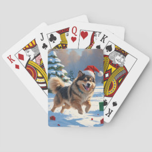 Finnischer Lapphund läuft durch Schnee mit Weihnac Spielkarten