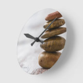 Fliesen aus dunkelfarbenen Steinen auf weißem Hint Runde Wanduhr (Winkel)