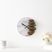 Fliesen aus dunkelfarbenen Steinen auf weißem Hint Runde Wanduhr (Zuhause)