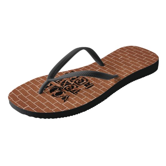 Flip-Flops an der Backsteinwand mit benutzerdefini Badesandalen (Schrägansicht)