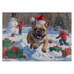Französische Bulldogge läuft im Schnee mit Weihnac Schneidebrett