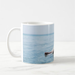 Frau auf einem aufblasbaren Schwimmer im Ozean, de Kaffeetasse