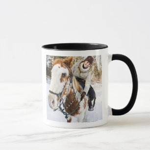 Frau auf Pferd draußen während des Winters Tasse