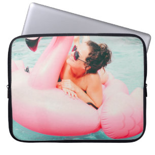 Frau auf rosa aufblasbarem Flamingo im Außenpool Laptopschutzhülle