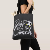 Frau des Fußballtrainers beansprucht den Trainer Tasche (Von Nahem)