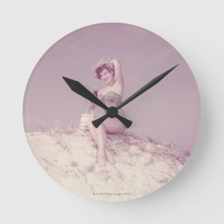 Frau, die auf Strand sich entspannt Runde Wanduhr