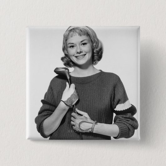 Frau, die Golfclub hält Button (Vorderseite)