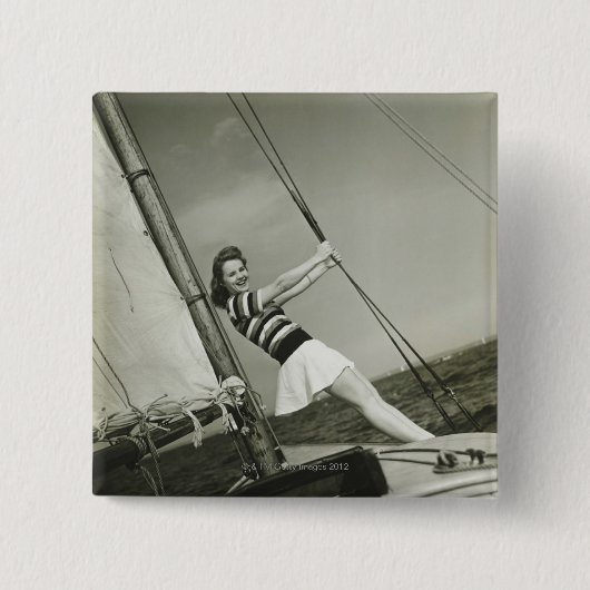 Frau, die Takelung auf Yacht hält Button (Vorderseite)