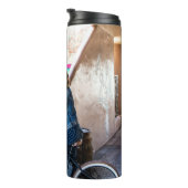 Frau trägt blaue Denim-Jacke und kurze Hosen  Thermosbecher (Nach rechts gedreht)