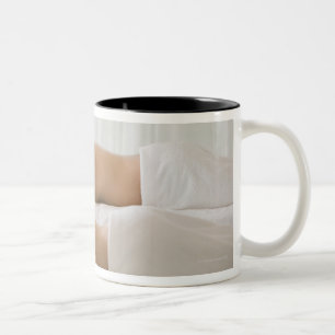 Frau und Mann, die auf Massagebänke liegen Zweifarbige Tasse