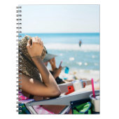 Frauen, die auf einer Sonnenliege liegen und ihr G Notizblock (Vorderseite)