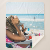 Frauen, die auf einer Sonnenliege liegen und ihr G Sherpadecke (Vorderseite)