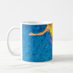 Frauen, die auf schwimmenden Schwimmbügeln aus Ku Kaffeetasse
