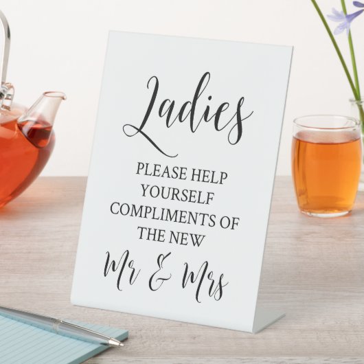 Frauen helfen Ihnen bitte beim Hochzeitsessen des Sockelschild (In Situ)