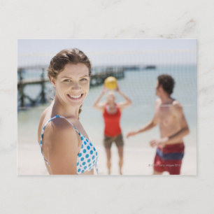 Freunde, die am Strand Volleyball spielen Postkarte