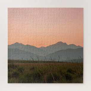 Friedliche rosa Sonnenuntergangsberge wilde Grasla Puzzle