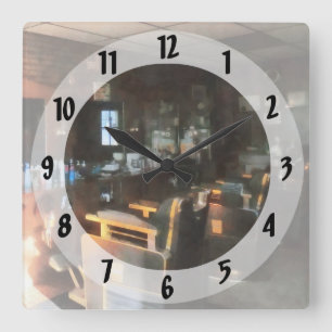 Friseursalon mit Sonnenstrahlen durchs Fenster Quadratische Wanduhr