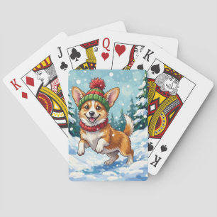 Fröhlicher Corgi-Hund springt im Schnee mit Pom-Po Spielkarten