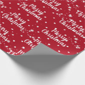 Fröhlicher Weihnachtstext in Schneeflocken auf rot Geschenkpapier (Ecke)