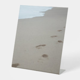 Fußabdrücke an einem weißen Strand in Mosambik Sockelschild