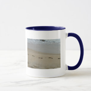 Fußabdrücke in der Tasse Sand