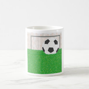 Fußball und Torpfosten auf grünem Grasfeld Kaffeetasse