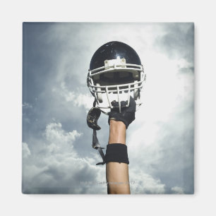 Fußballspieler, der Sturzhelm in einer Luft hält Magnet