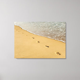 Fußdrucke im Sand mit Welle Leinwanddruck