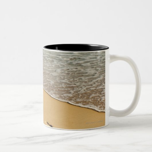 Fußdrucke im Sand mit Welle Zweifarbige Tasse (Rechts)