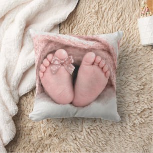 Füße eines Babymädchens mit einer gepunkteten Schl Kissen