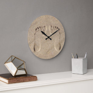Fußspuren im Sand am Strand Große Wanduhr
