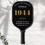 Geburtsname 1944 Black Gold Elegant Chic Pickleball Schläger<br><div class="desc">Chic '1944' 80th Birthday Black and Gold Personalisiert Pickleball Paddle - Elegantes Design für Sportbegeisterte. Feiern Sie mit unserem schicken Paddel '1944' zum 80. Geburtstag einen Meilenstein im Stil. Dieses elegant gestaltete und vollständig personalisierte Paddel verbindet Geburtstagscharme und Nützlichkeit in einem. Dieses Paddel ist ideal für alle, die eine Leidenschaft...</div>